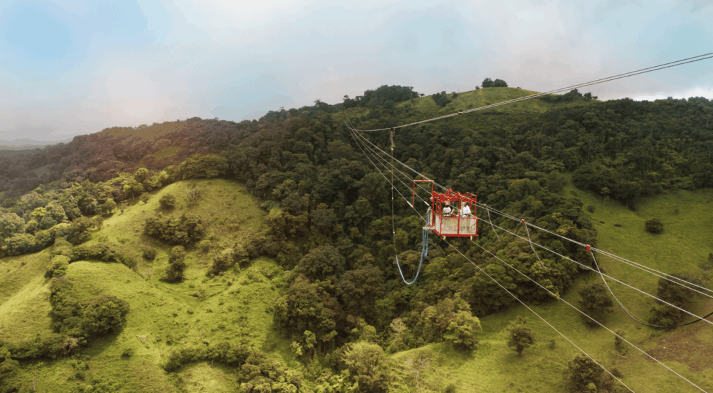 Turistas em plataforma suspensa para bungee jump sobre a floresta nublada na Costa Rica.